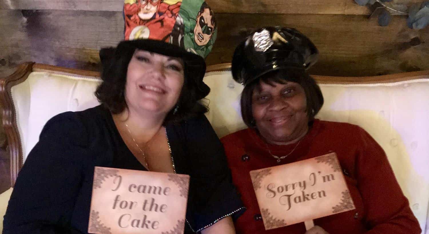 Two women smiling and wearing props for wedding reception photos