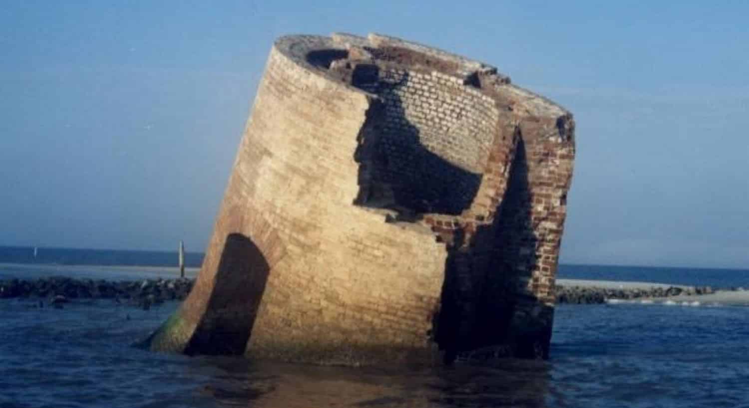 The broken base of Round Island lighthouse sitting in water after the hurricane