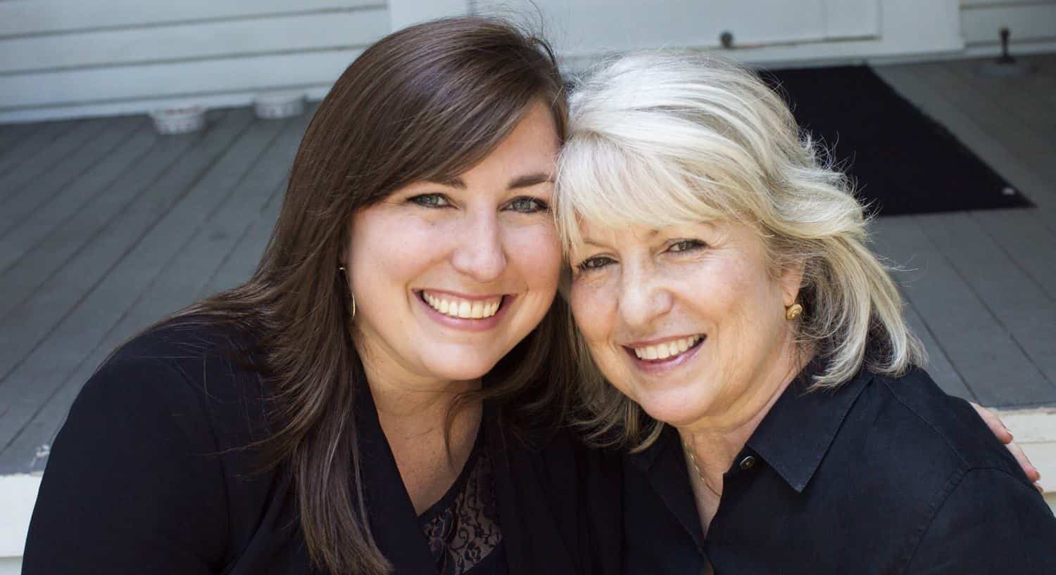 Owner sitting next to another woman on the porch and smiling