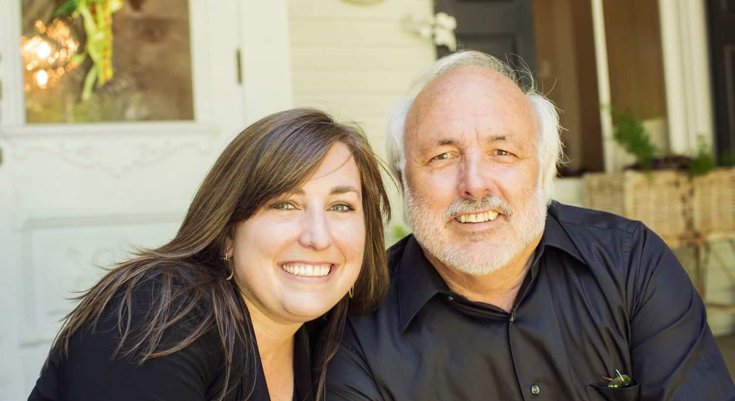 Owners, husband and wife sitting outside and smiling