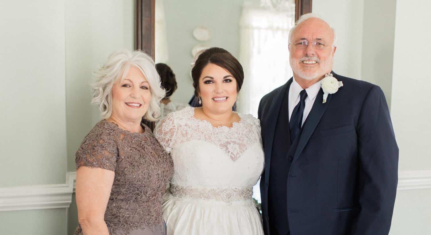 Owners on their wedding day standing next to another woman