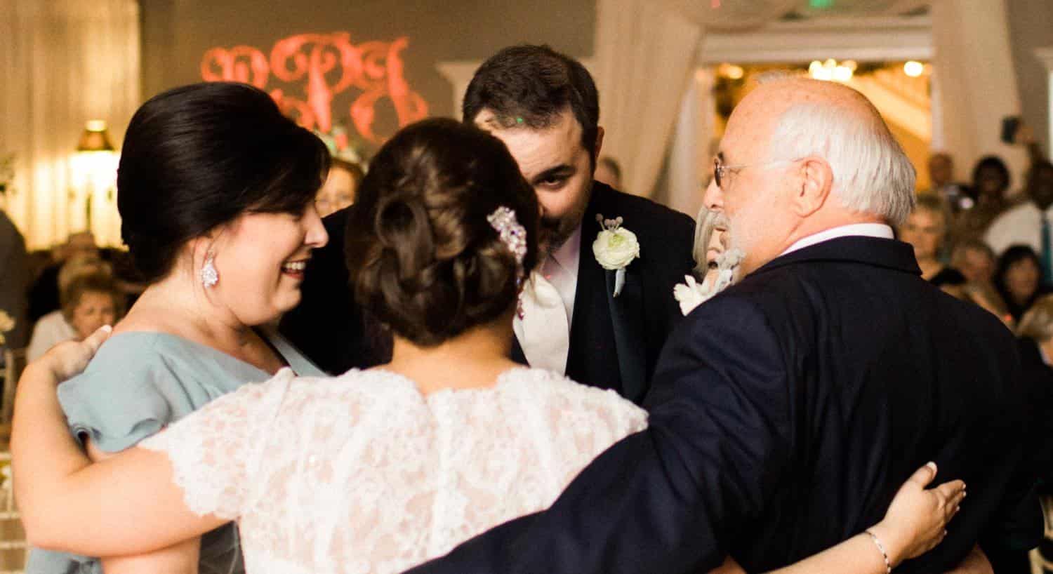 Owners on their wedding day embracing in a circle with two others